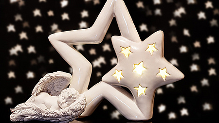 Schwarzer Hintergrund mit weißen Sternchen, Vordergurnd: zwei weiße verschieden große  Sterne und einem kleinen weißen Engel. weißen