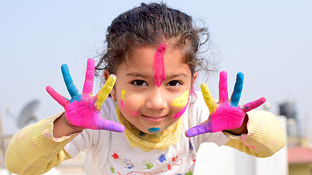 Mädchen mit bemalten Handflächen und Gesicht (Quelle: Prashant Sharma auf Pixabay)