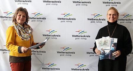 Erste Kreisbeigeordnete Stephanie Becker-Bösch und Anette Obleser stellen die 43. Ausgabe der Selbsthilfezeitung für die Wetterau vor.